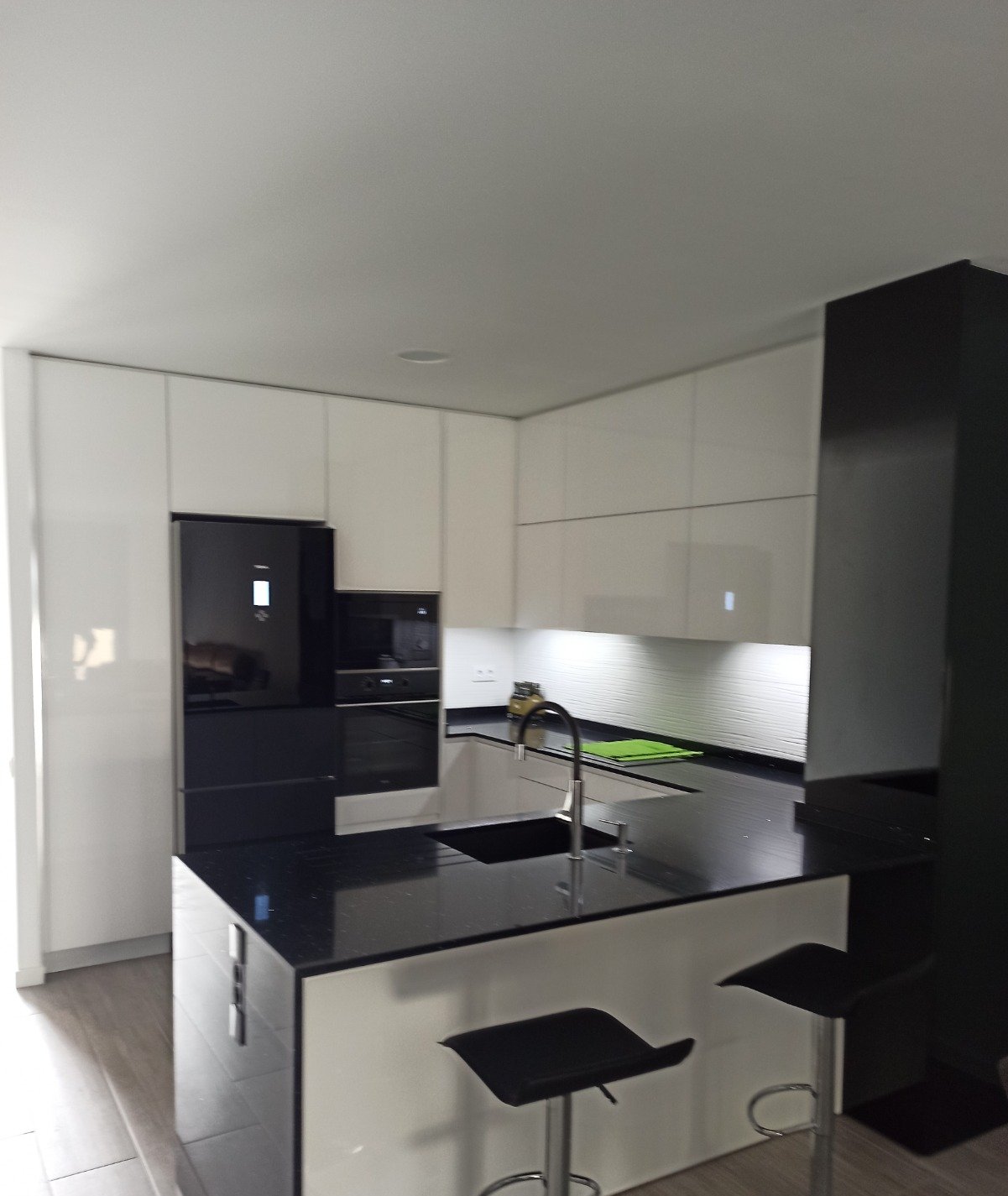Cocina reformada por Reformas CC García, con isla en blanco y negro